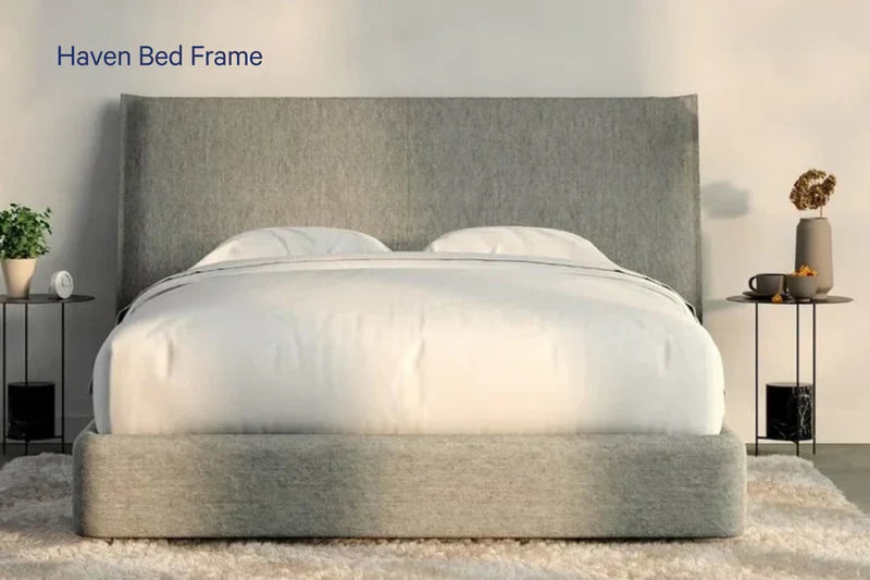 Modern grey upholstered bed frame with white bedding in a cozy bedroom setting