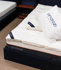 Comfortable mattress topped with white bedding and pillows, indoor bedroom setting