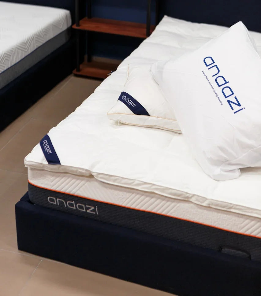 Comfortable mattress with white bedding and pillows in a modern bedroom