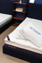 Modern bedroom with an Andazi mattress, white bedding, and an Andazi pillow on a bed frame