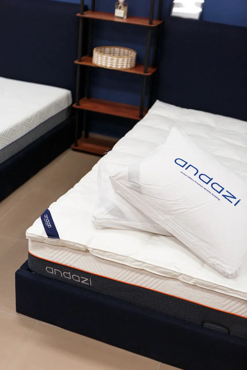 Comfortable modern mattress with white topper and branded pillow in a bedroom setting