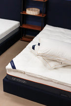 Comfortable white mattress with two pillows on a modern bed frame in a cozy bedroom