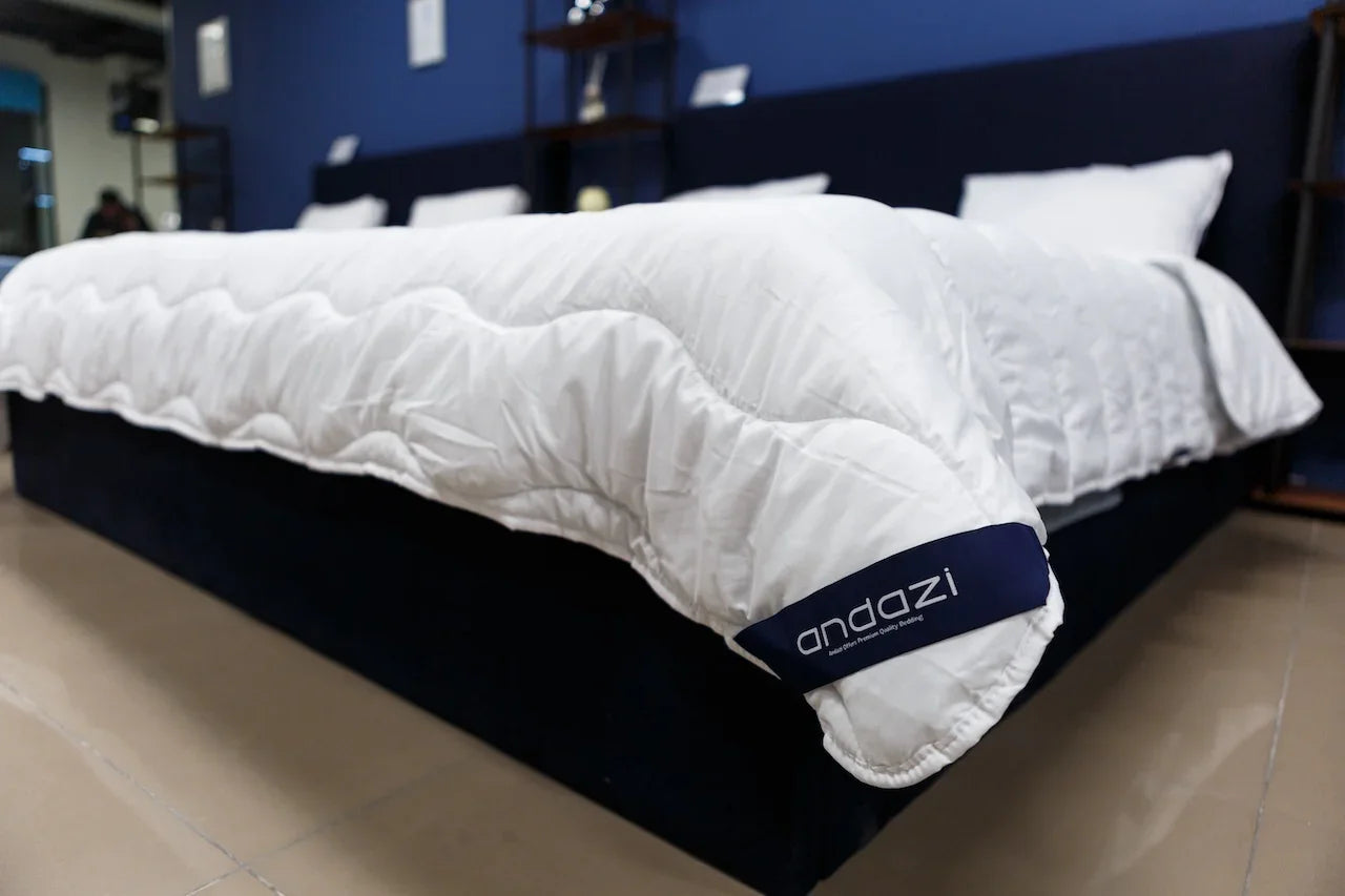 Close-up of a white quilted mattress with visible 'andazi' label in a modern bedroom.