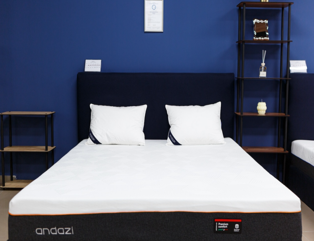 Modern bedroom with a premium comfort mattress, black bed frame, and white pillows