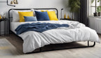 Modern metal bed base with white bedding, yellow and blue pillows, in bright bedroom