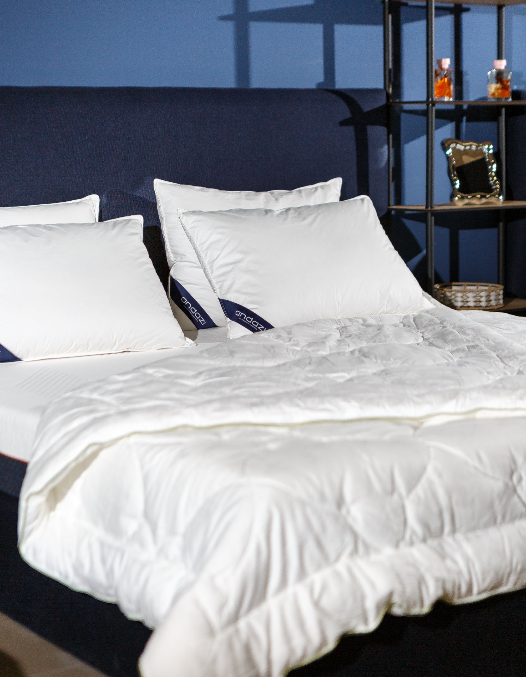 Modern bed with white mattress, fluffy comforter, and pillows in a cozy bedroom