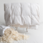 White down comforter with exposed feathers on a white background
